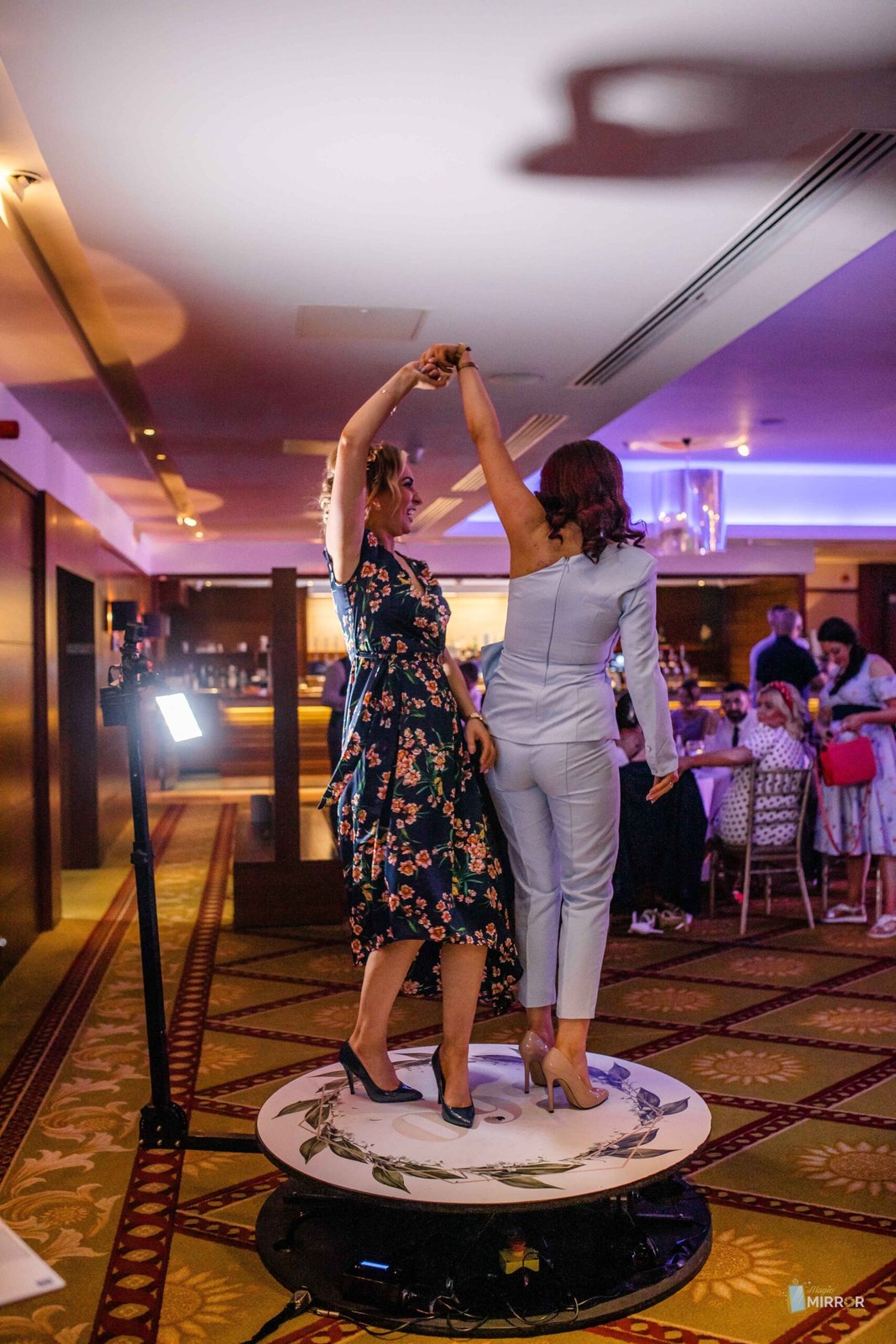 Two guests dancing beside the 360 booth at a reception