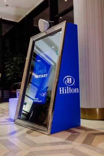 Hilton-branded mirror booth with touch-to-start screen