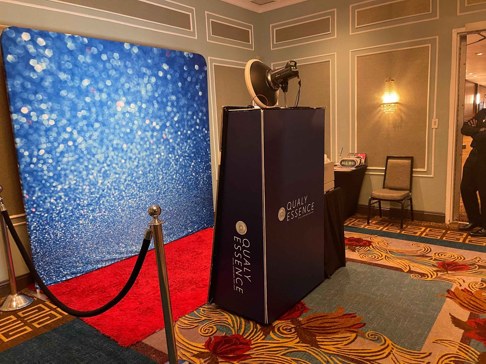 Custom-wrapped booth with blue sequin backdrop and red carpet at a gala