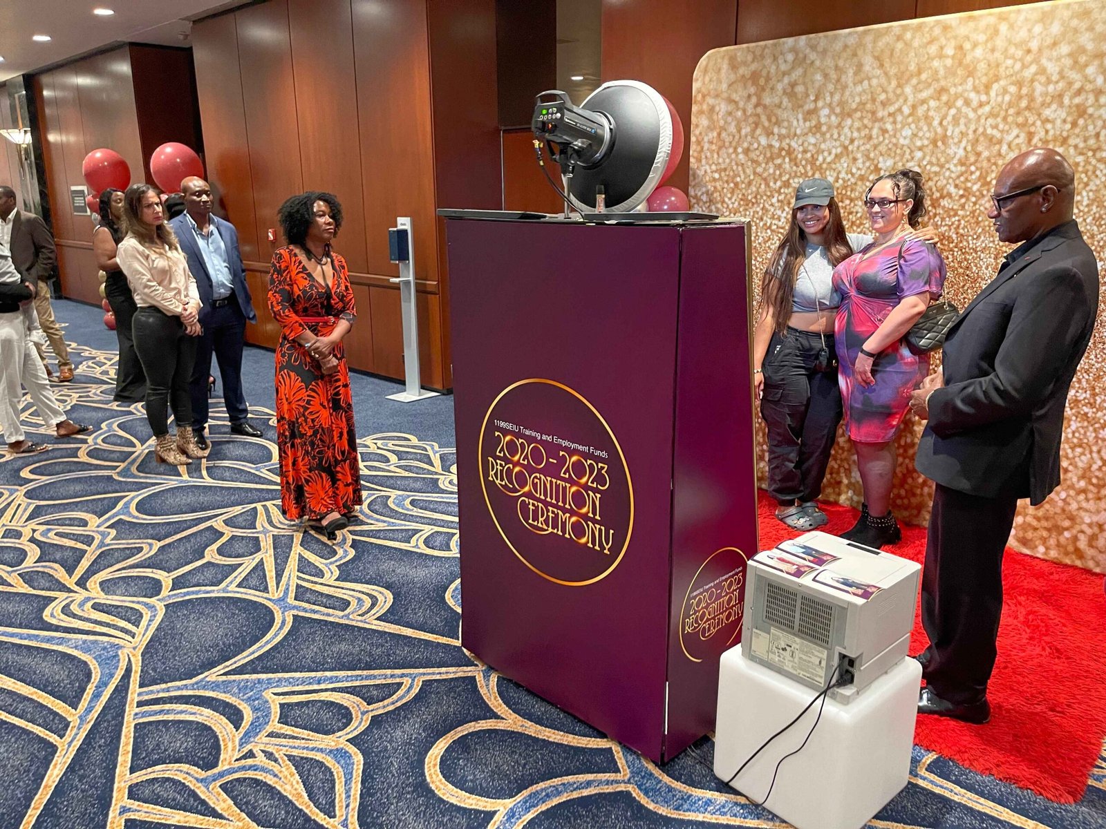 Guests lining up at a custom-wrapped booth at a gala event