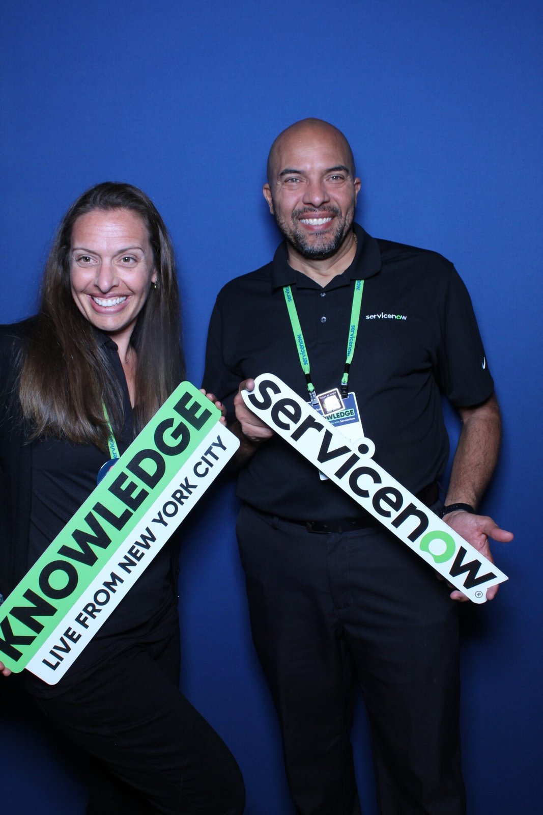 Attendees posing with ServiceNow signs at a branded conference booth