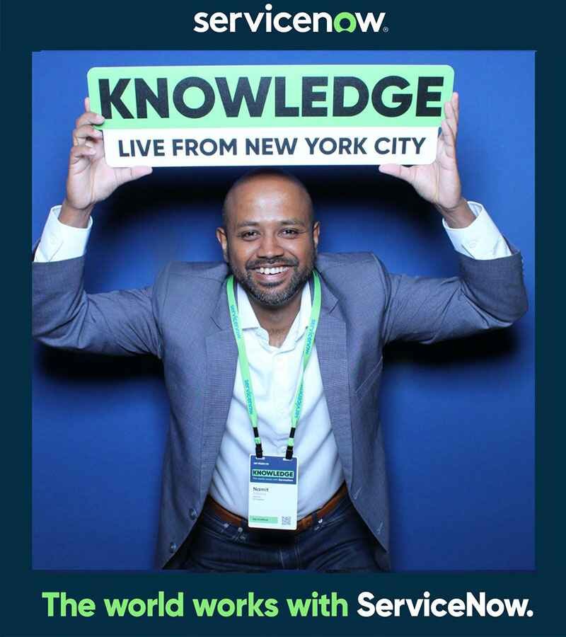 Attendee holding a Knowledge Live from New York sign at a branded booth