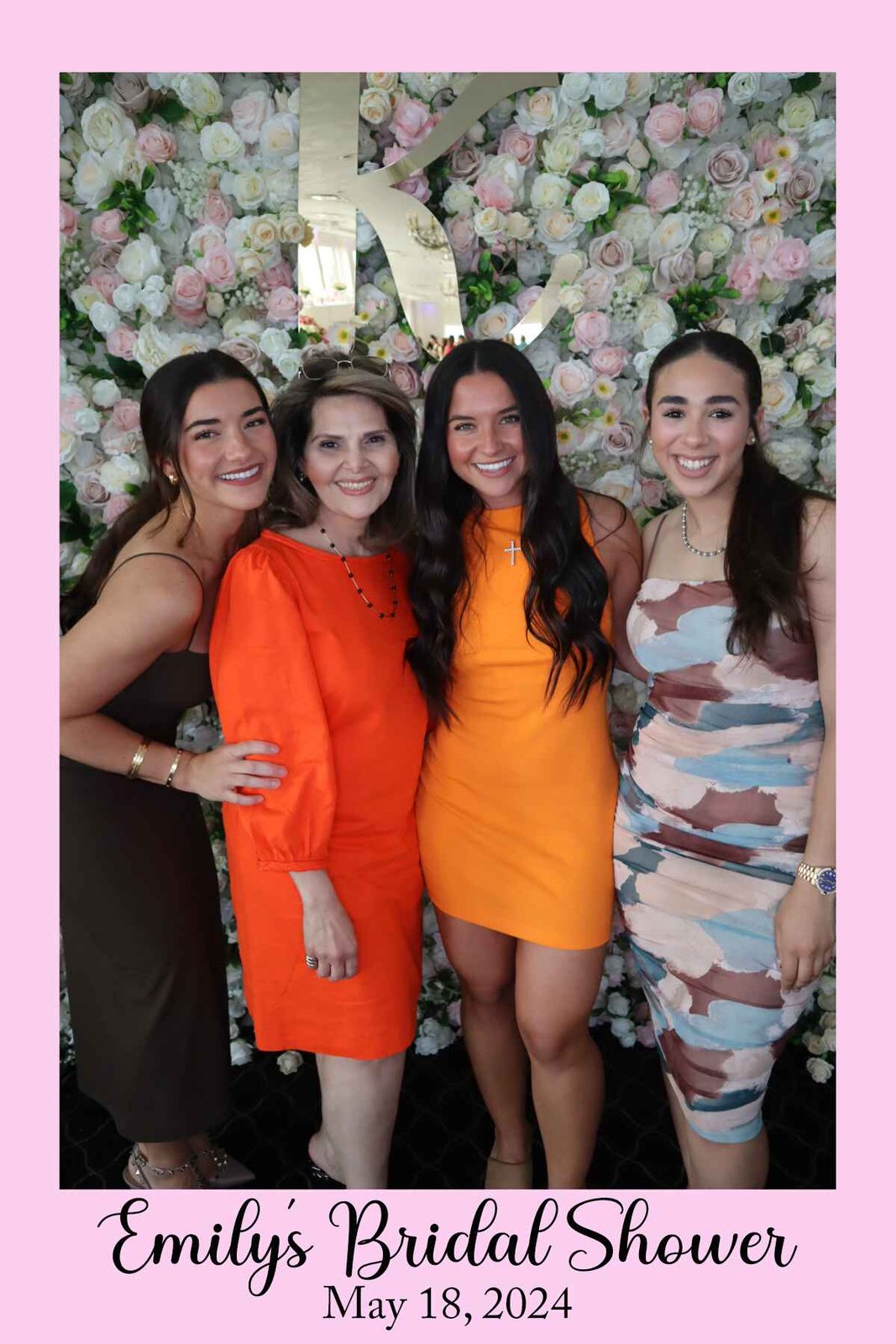Guests posing at the champagne celebration flower wall