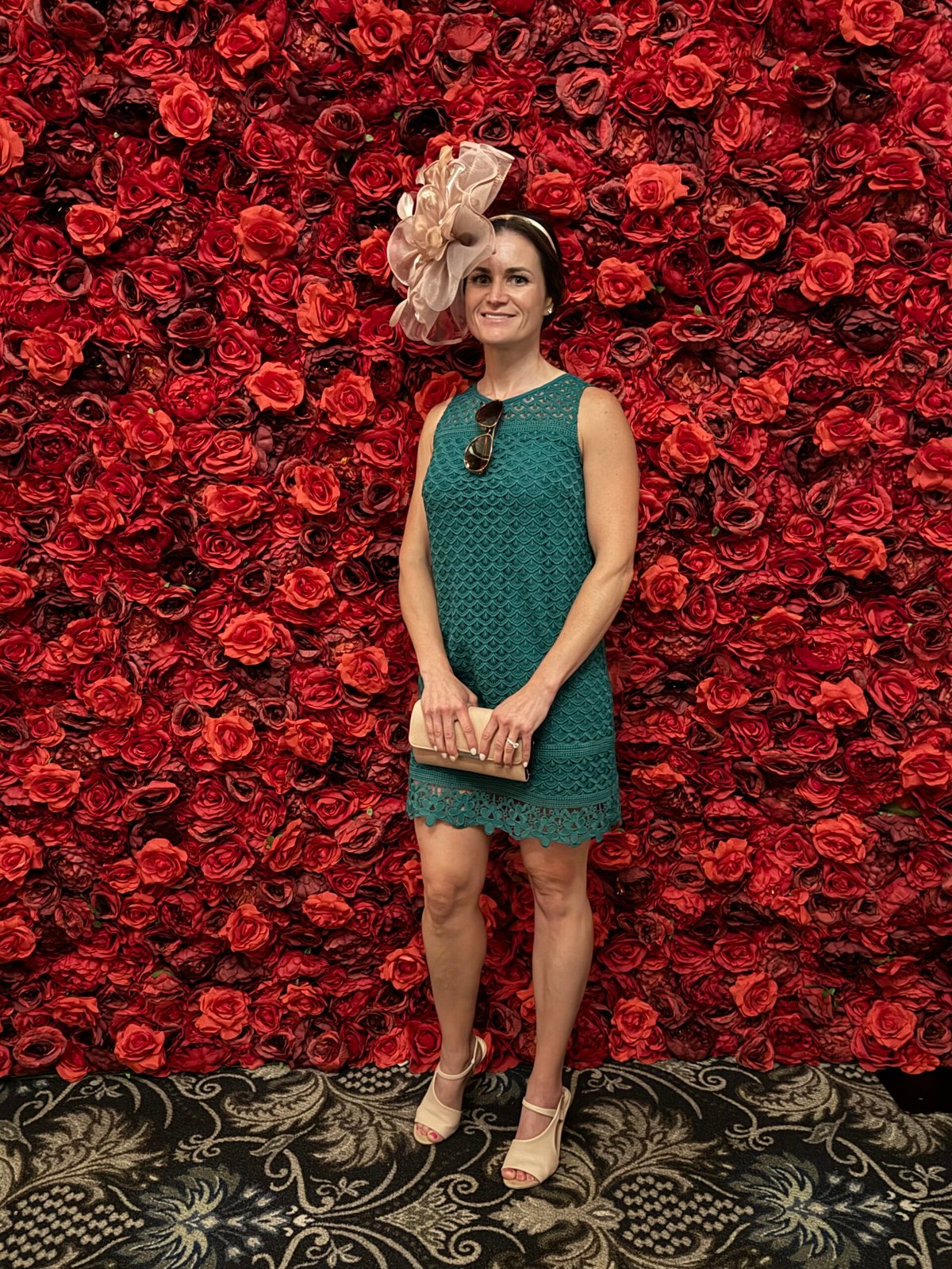 Guest posing in front of the red flower wall