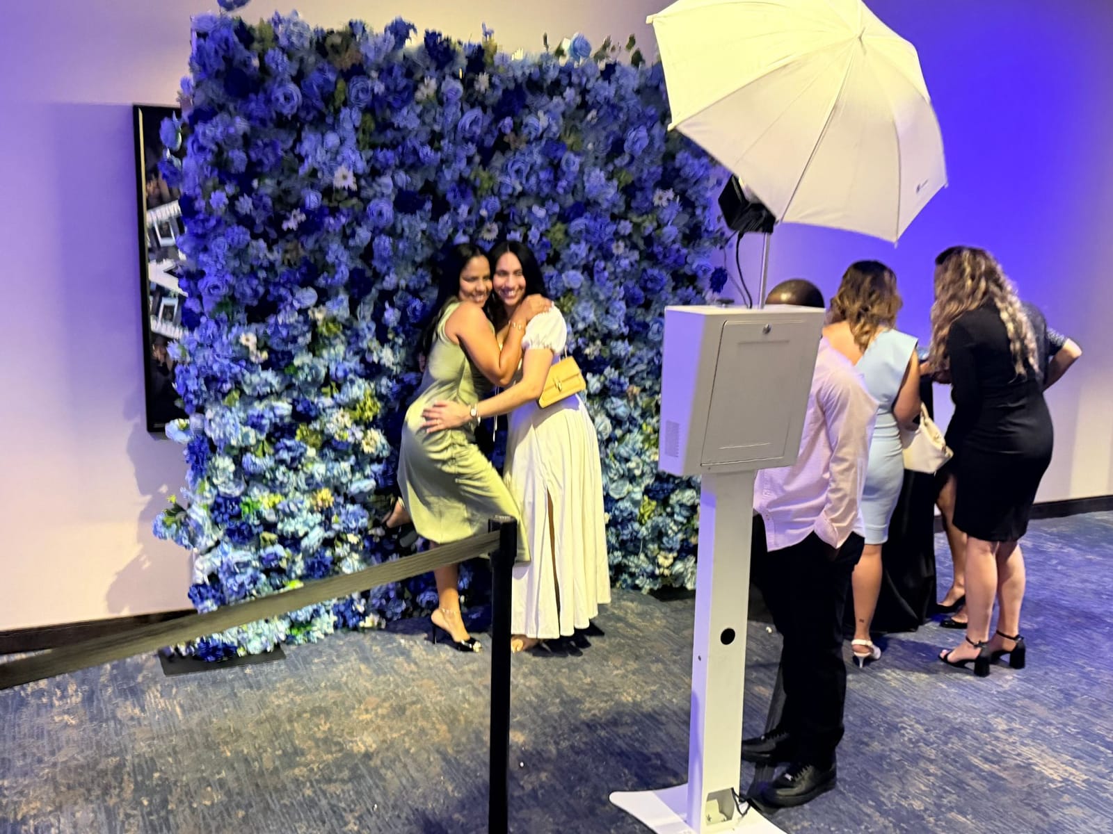 Blue flower wall with photo booth and lighting set up at an NYC event