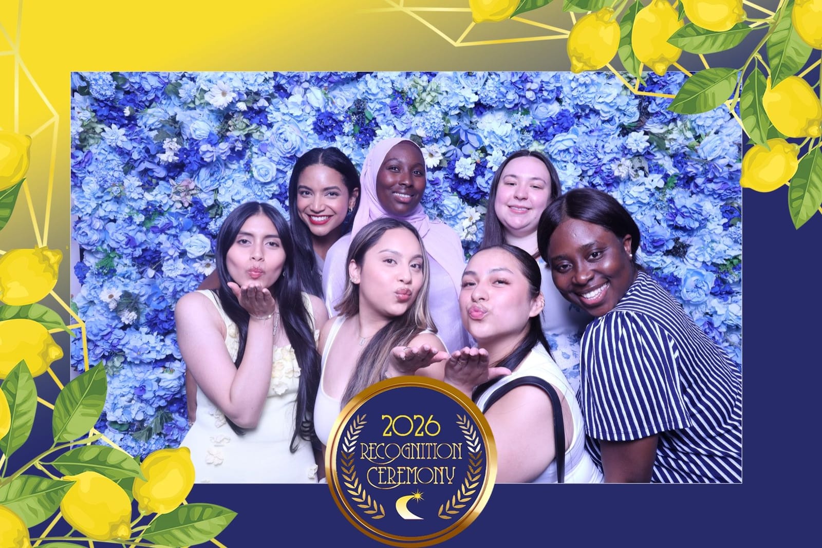 Friends blowing kisses at the blue flower wall photo booth