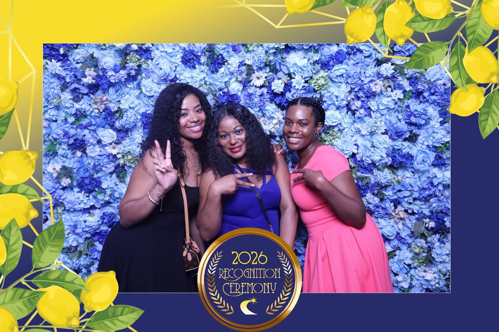 Three guests smiling at the blue flower wall photo booth