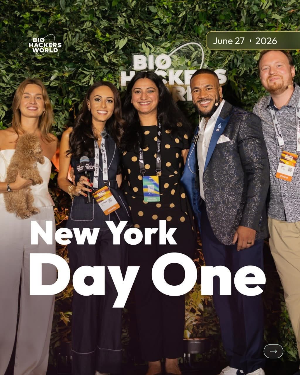 Conference hosts in front of the green hedge wall backdrop in New York