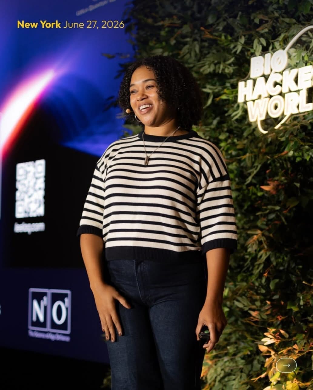 Speaker on stage at the greenery wall backdrop at a corporate conference