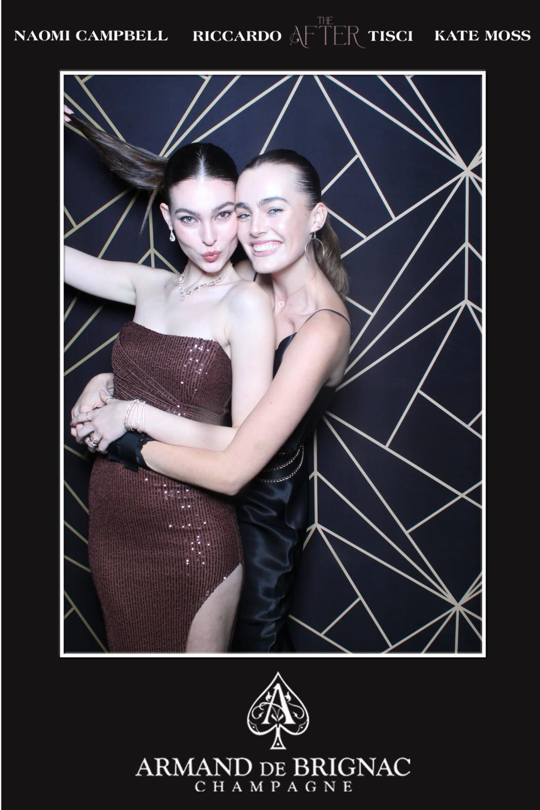 Two guests in evening dress at the Armand de Brignac after-party photo booth