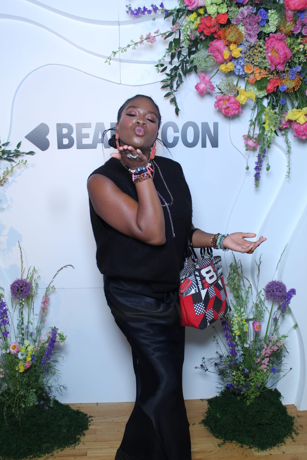Guest posing at the Beautycon floral backdrop