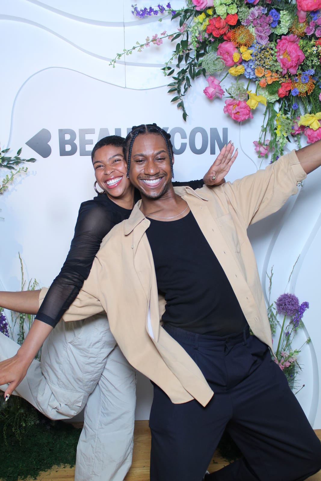 Two guests posing playfully at the Beautycon photo booth