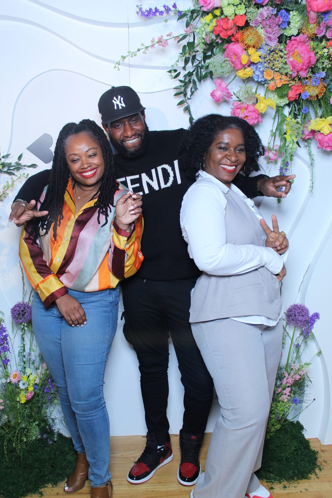 Three attendees in streetwear at the Beautycon step-and-repeat