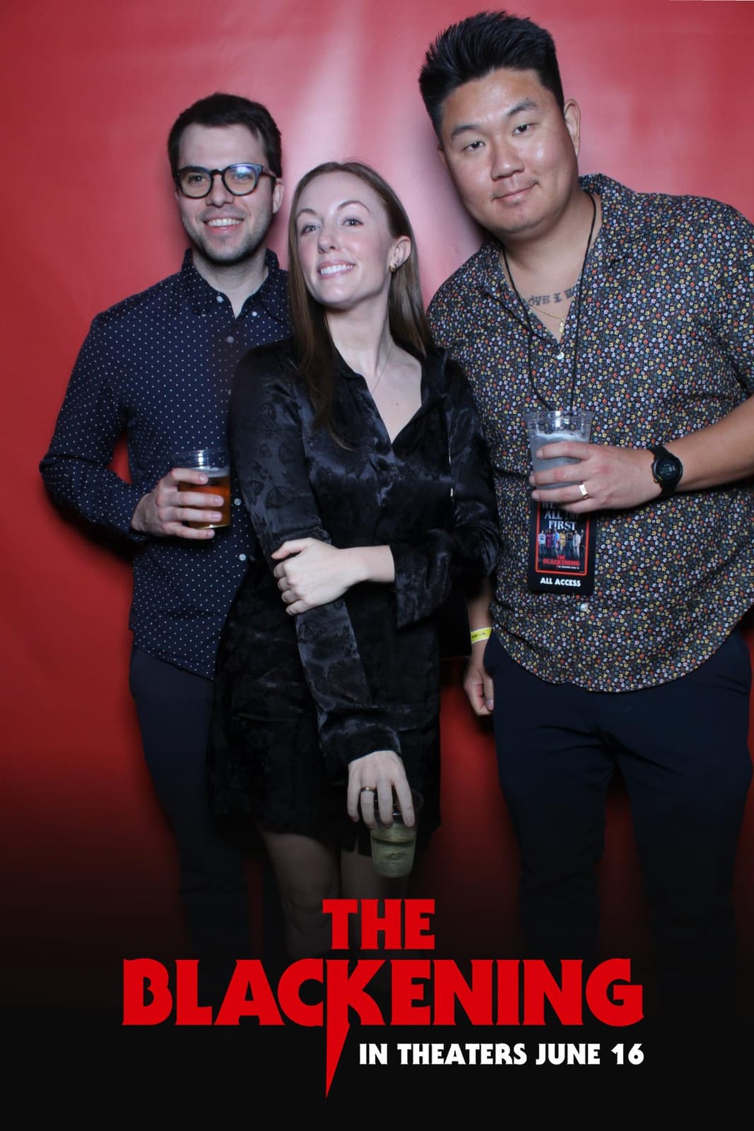 Guest posing at The Blackening film premiere photo booth — red backdrop with the film's print frame