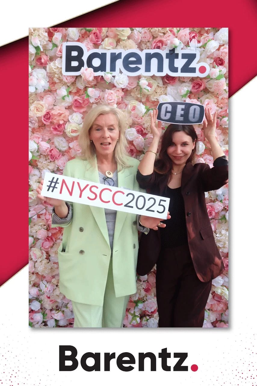 Two guests having fun with a CEO prop at the Barentz NYSCC 2025 activation