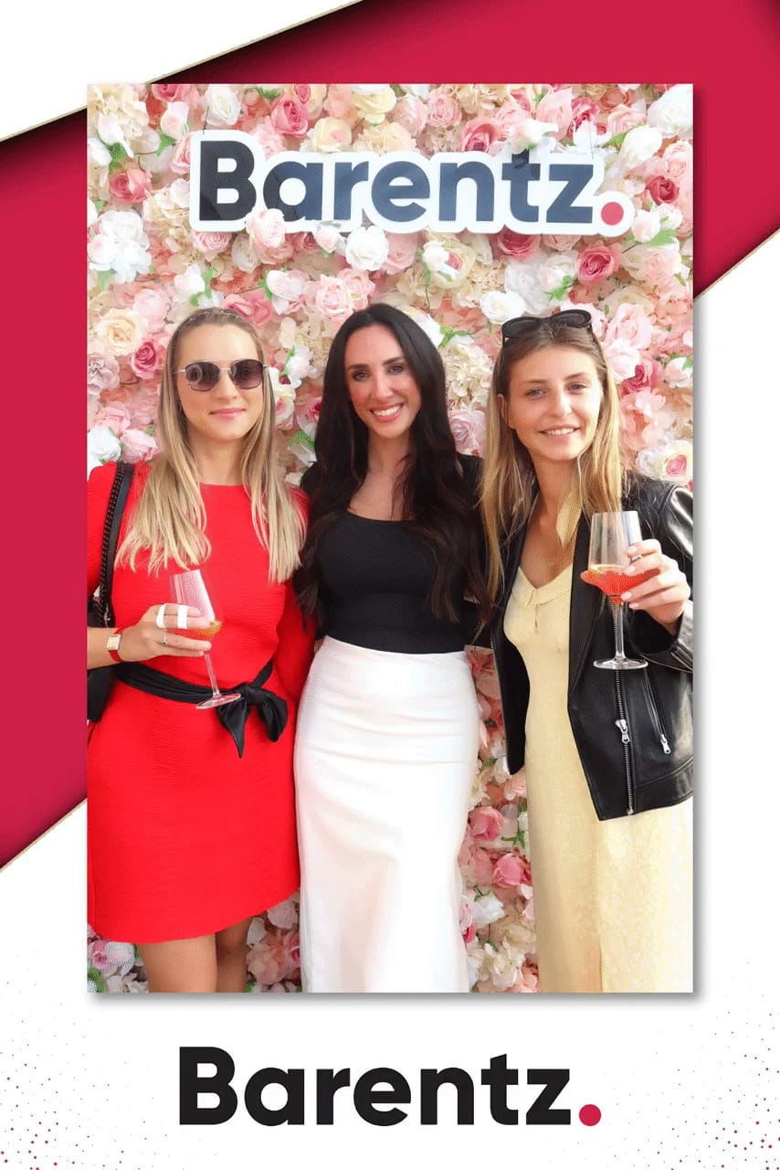 Three friends with drinks at the Barentz flower wall at NYSCC 2025