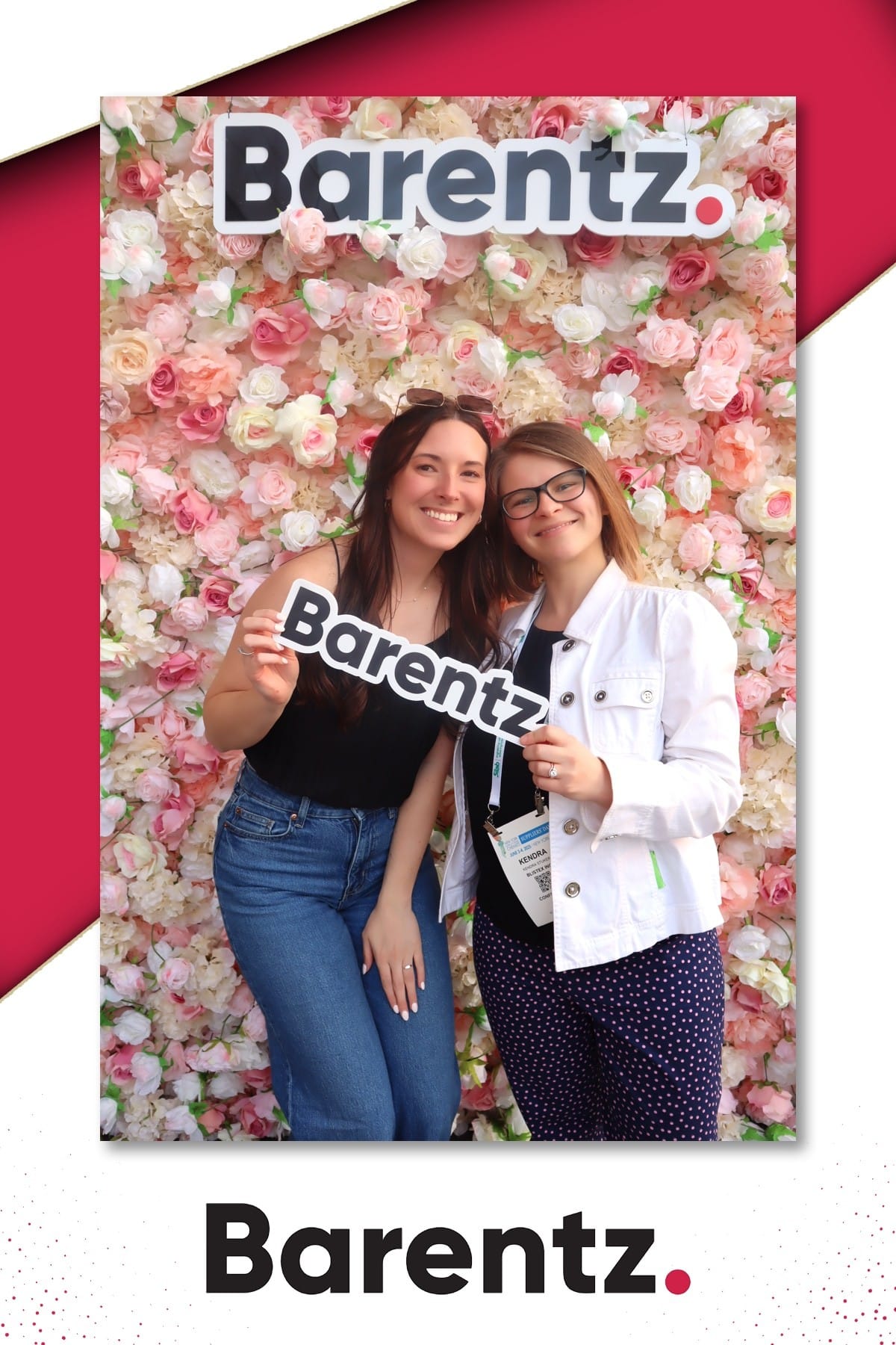 Two guests with a Barentz prop at the branded flower wall