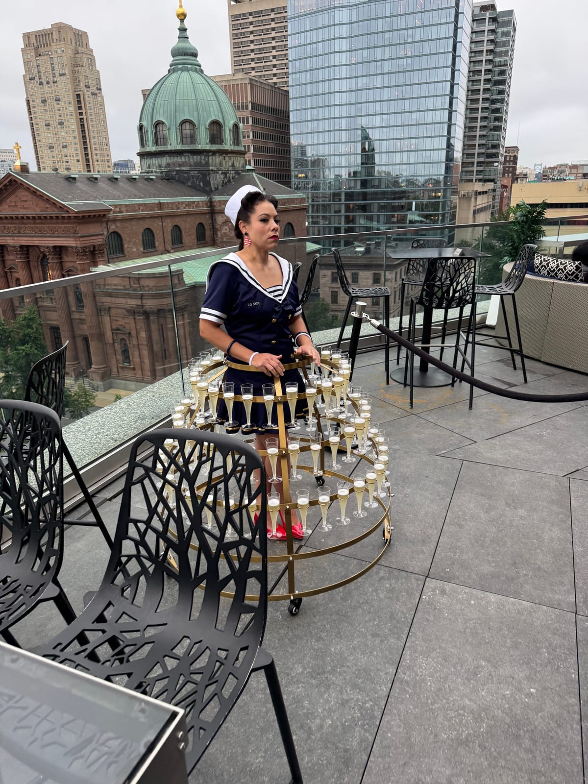 Guest posing on the rooftop terrace at the Captain's Ball with a city skyline view
