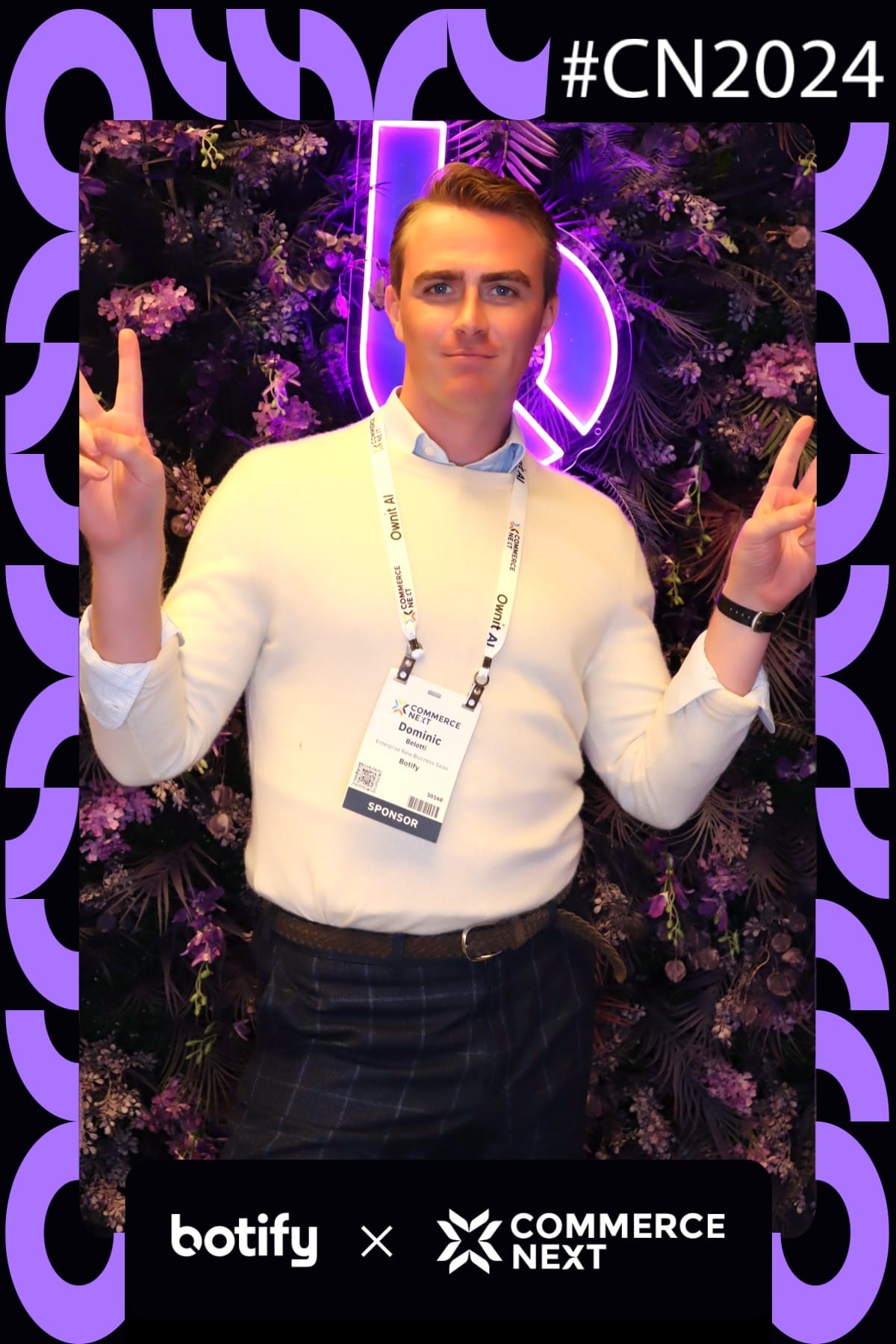 Sponsor rep giving peace signs at the Botify x CommerceNext neon flower wall — #CN2024 print frame
