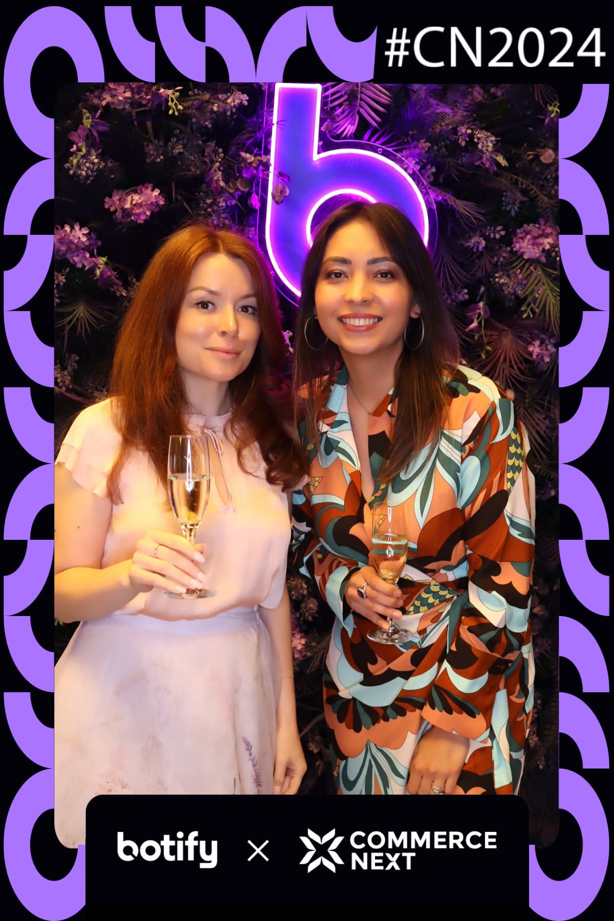 Two guests toasting with champagne at the Botify x CommerceNext photo booth
