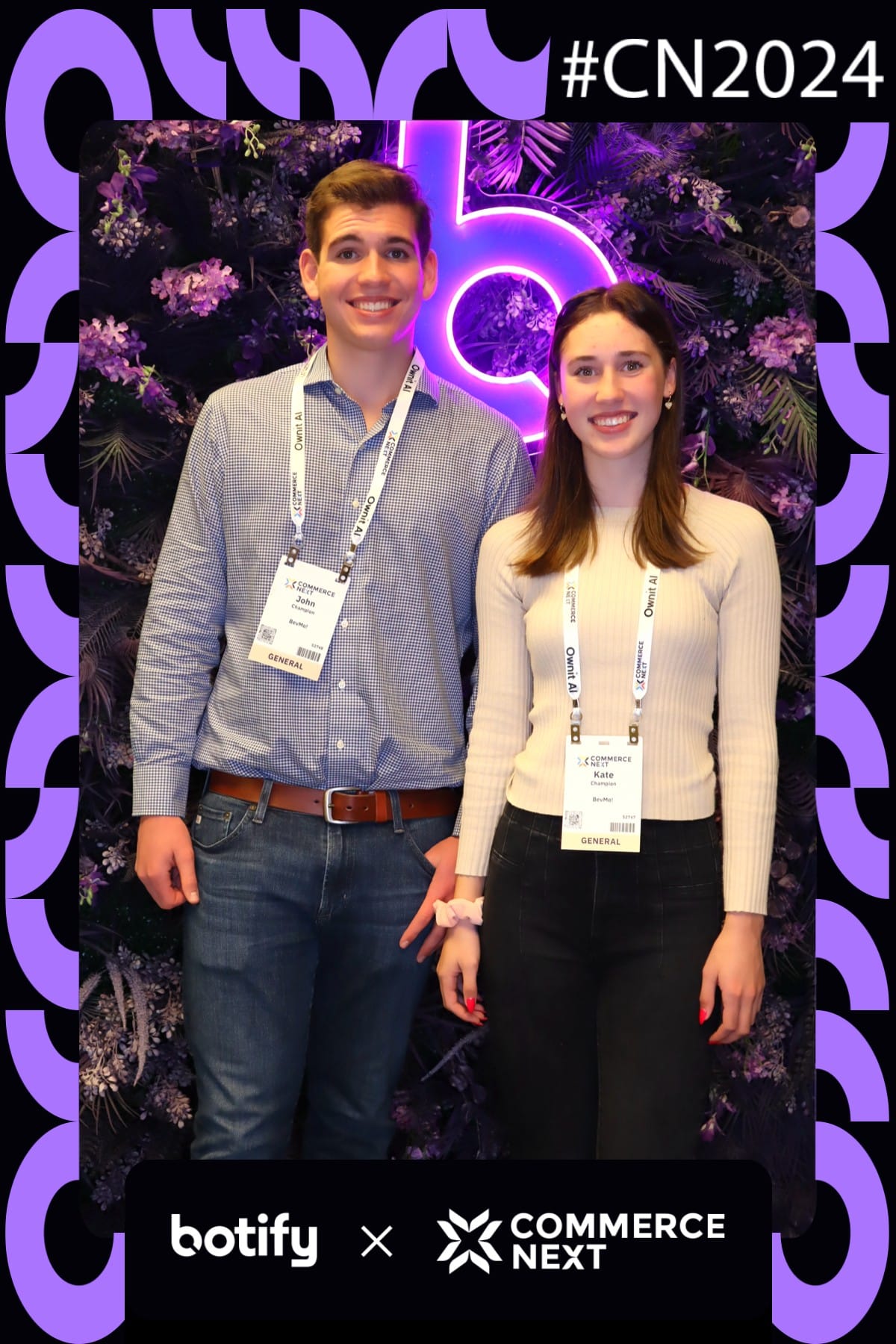 Two conference attendees posing at the CommerceNext neon flower wall