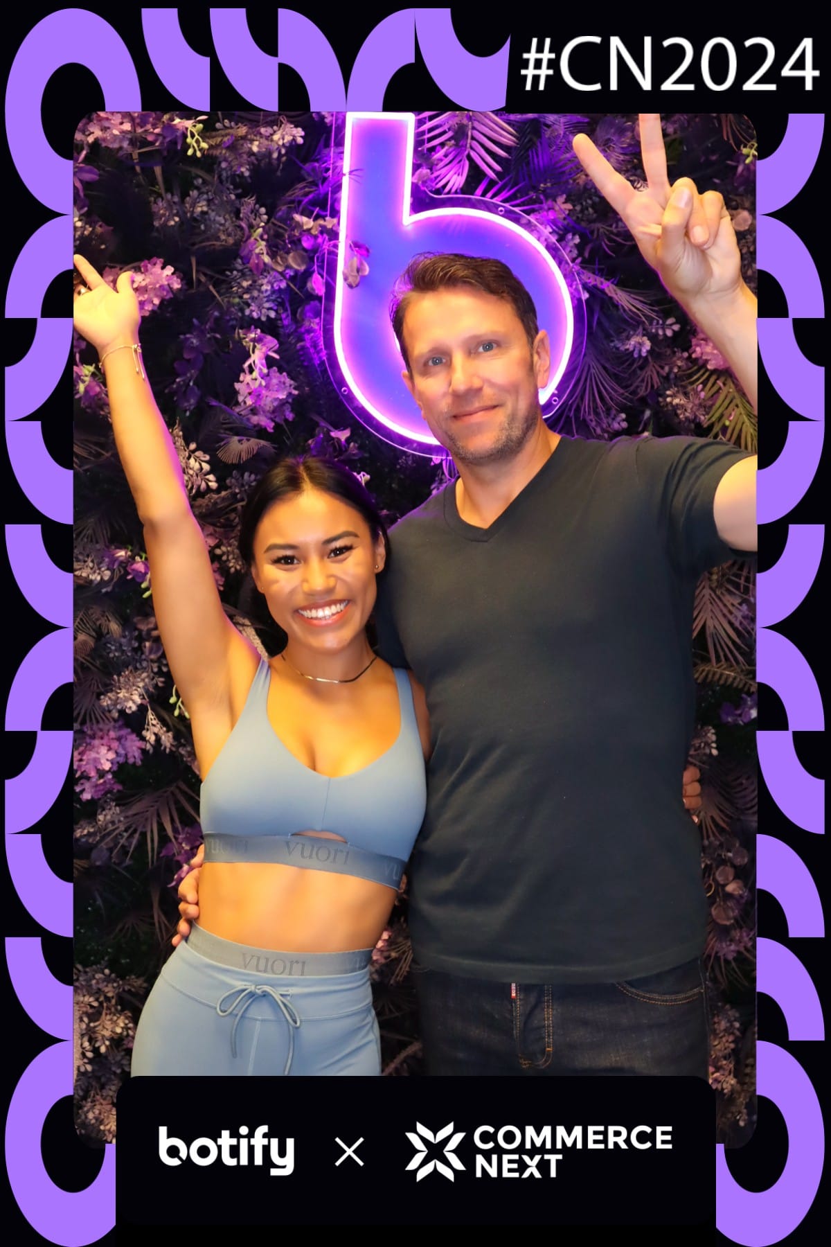 Guest in workout gear posing with a colleague at the CommerceNext photo booth