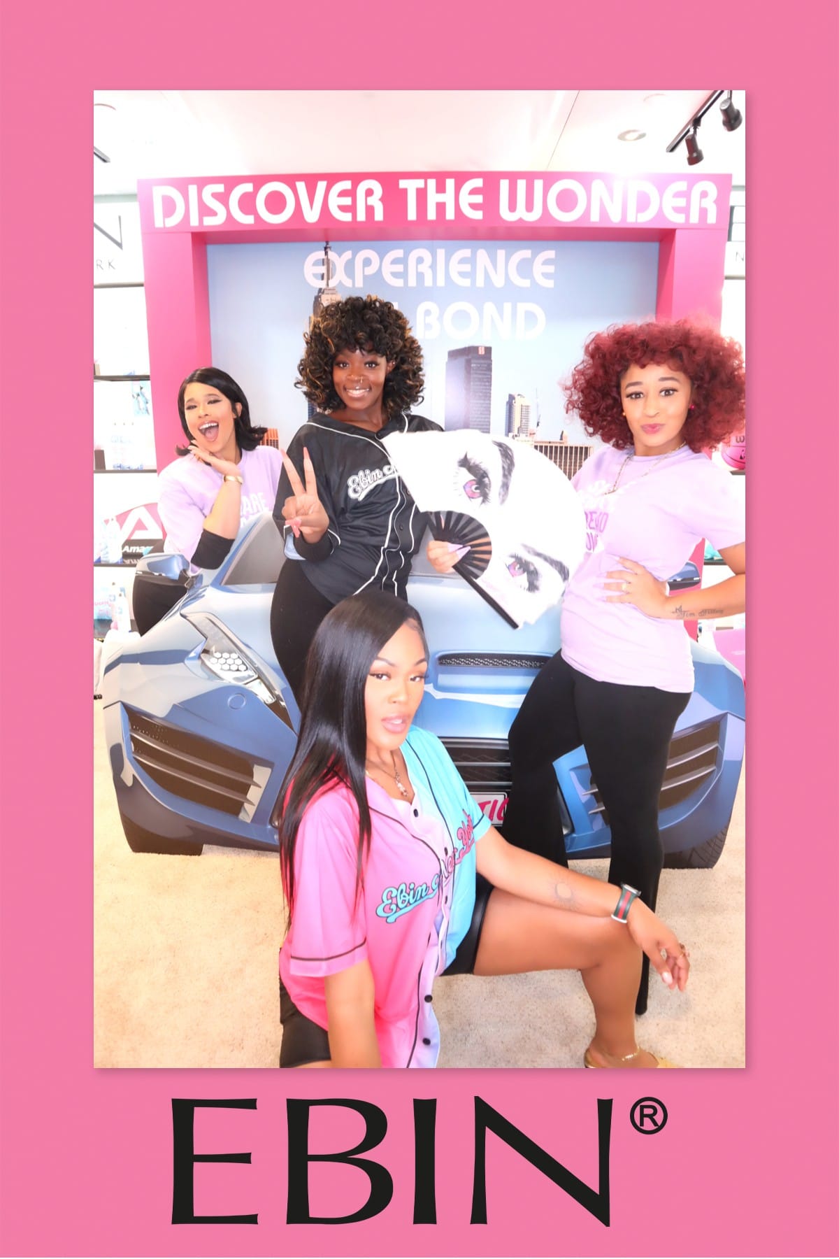 Four guests in EBIN branded jerseys posing at the sports-car photo prop