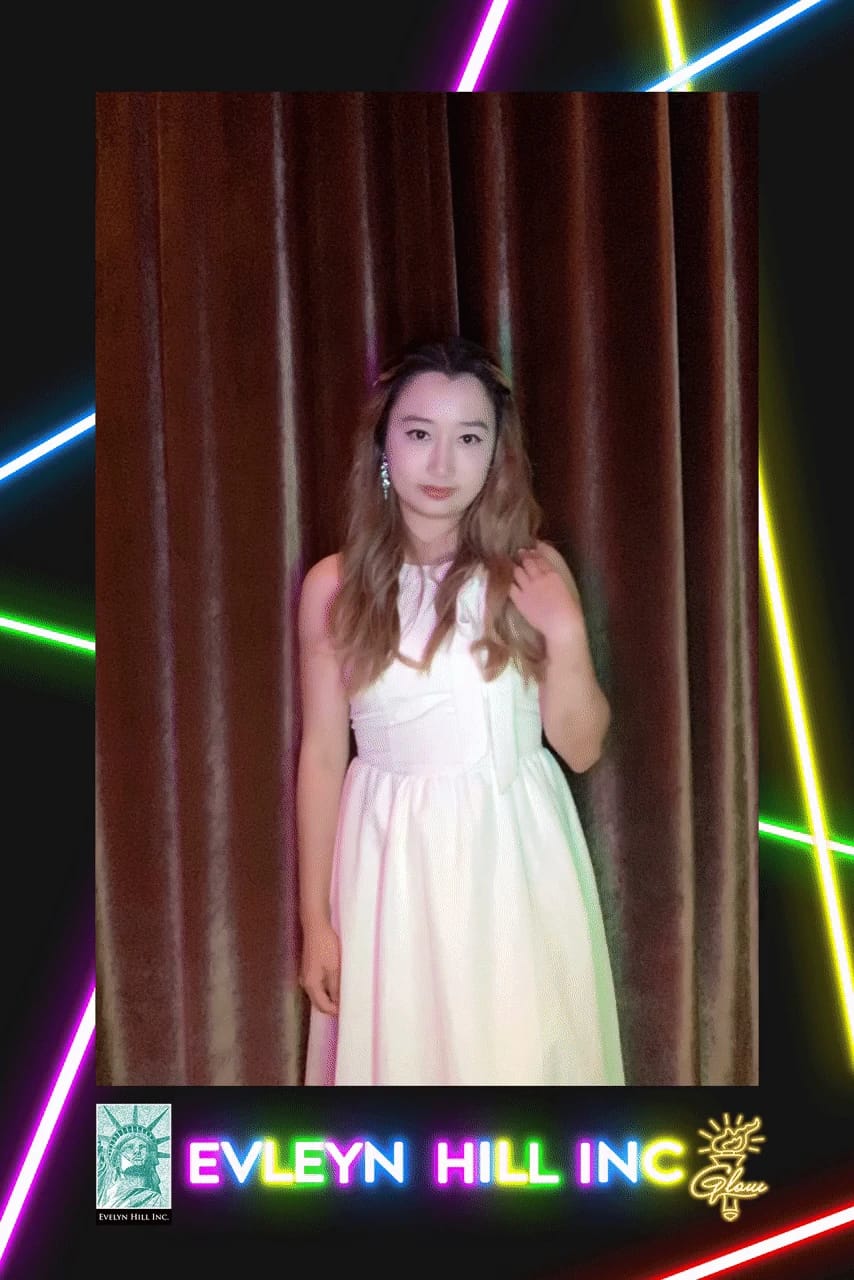 Guest posing in front of the velvet curtain at the Evelyn Hill Inc company dinner