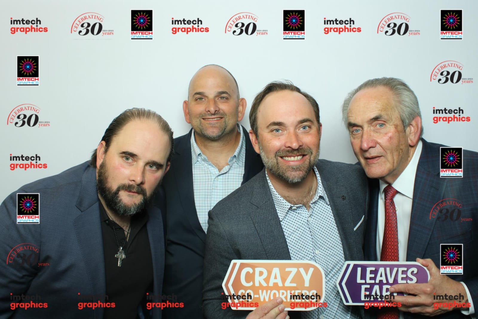 Colleagues with I Need a Vacation and Crazy Co-Workers props at the Imtech Graphics photo booth