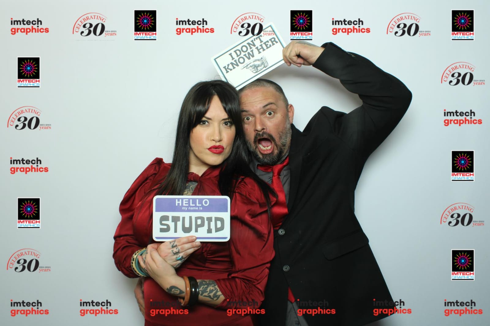 Colleagues posing with a funny prop at the Imtech Graphics anniversary booth