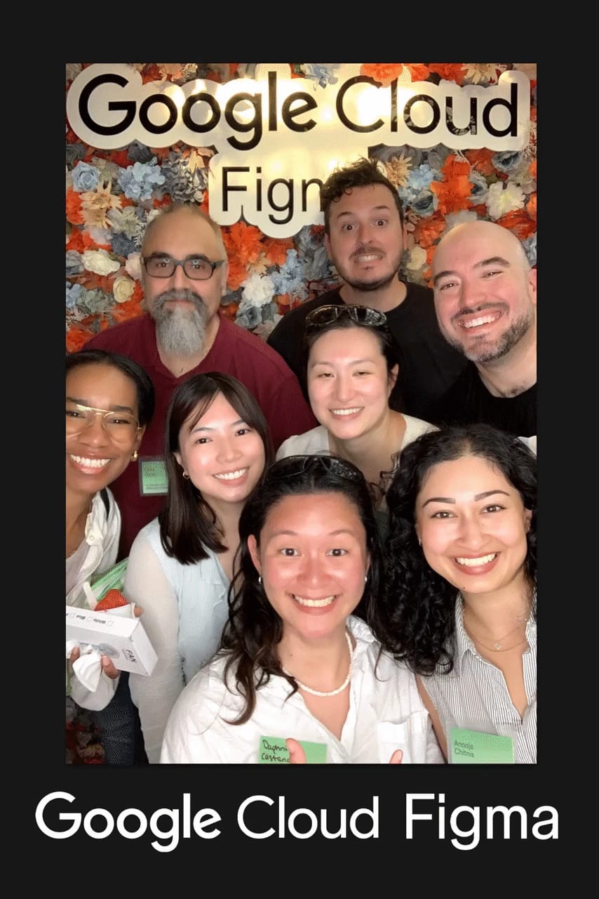 Eight guests crowd into the frame at the Google Cloud × Figma event — flower wall photo booth by Magic Mirror Brooklyn