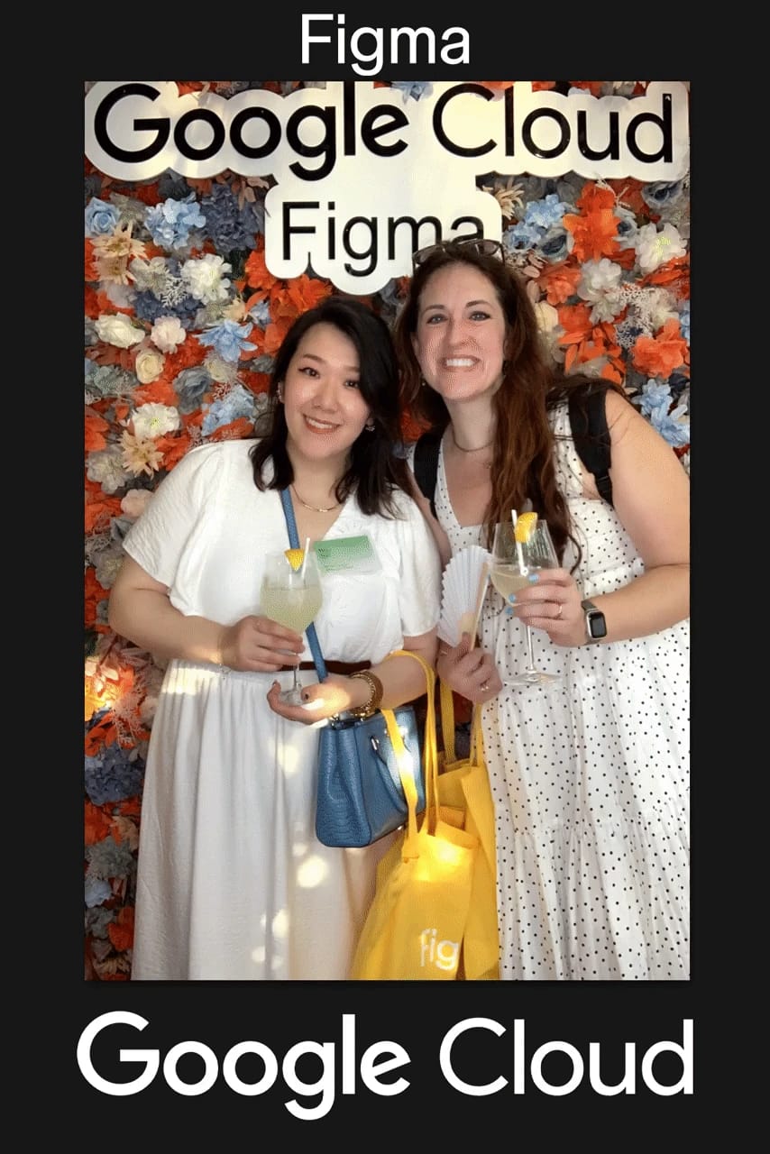Two guests with cocktails in front of the orange and blue flower wall at the Google Cloud × Figma mixer