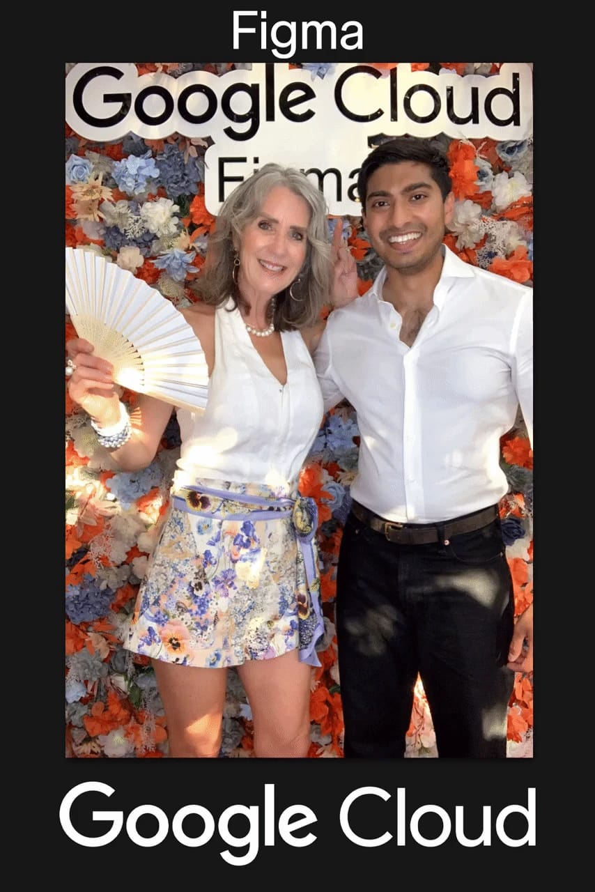 Two guests posing under the Google Cloud Figma sign at the branded flower wall