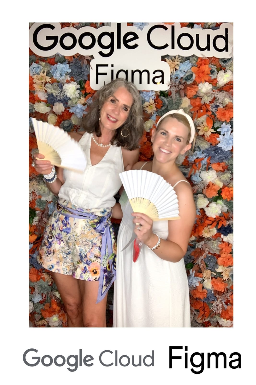 Two guests cooling off with fans at the Google Cloud × Figma event photo booth