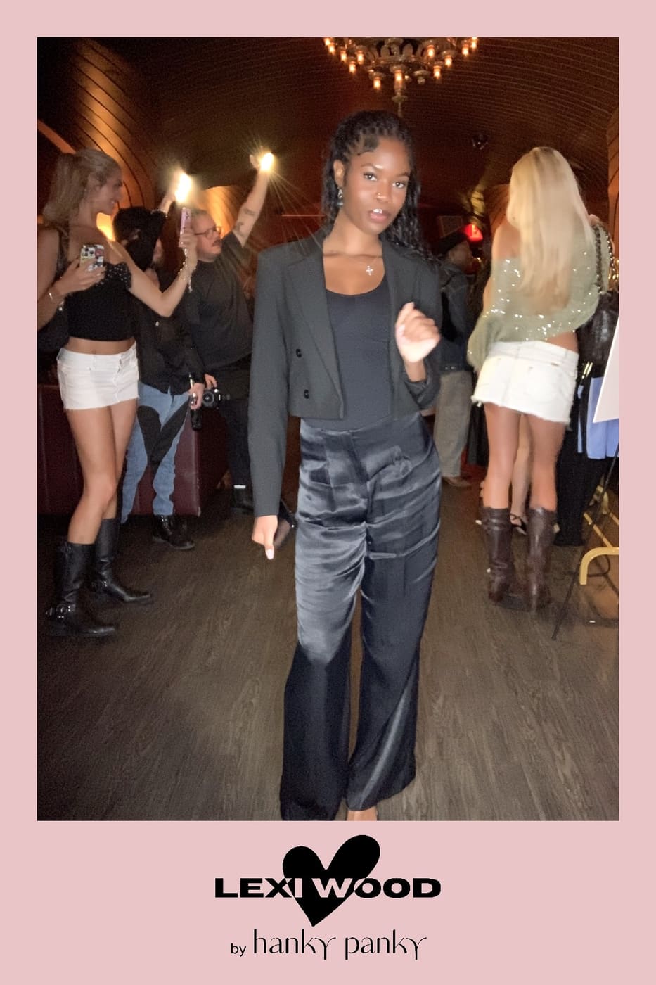 Guest in a cropped blazer and satin trousers posing at the Lexi Wood by Hanky Panky launch