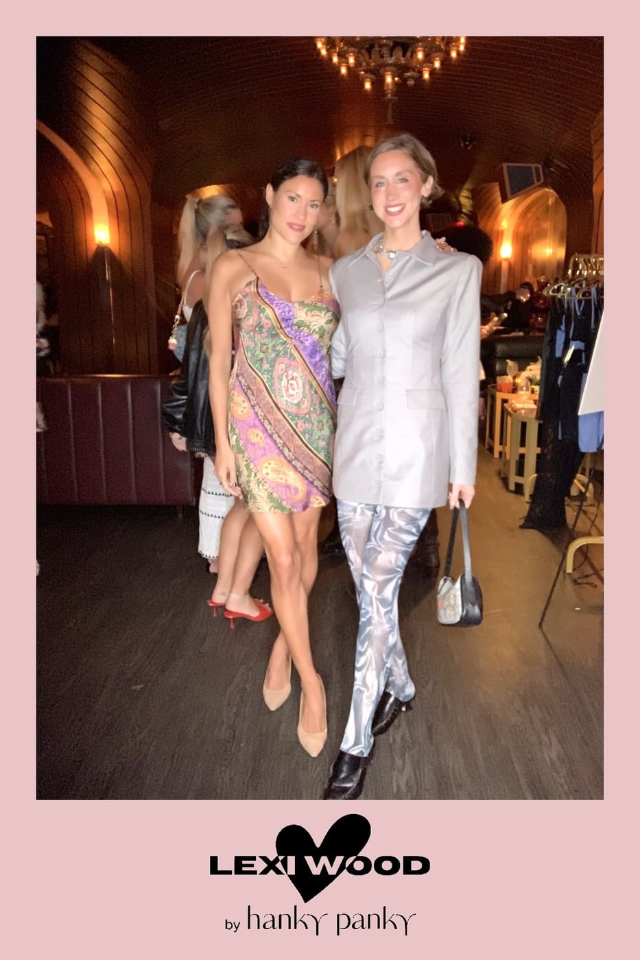 Two guests posing in a paisley slip dress and tailored suit
