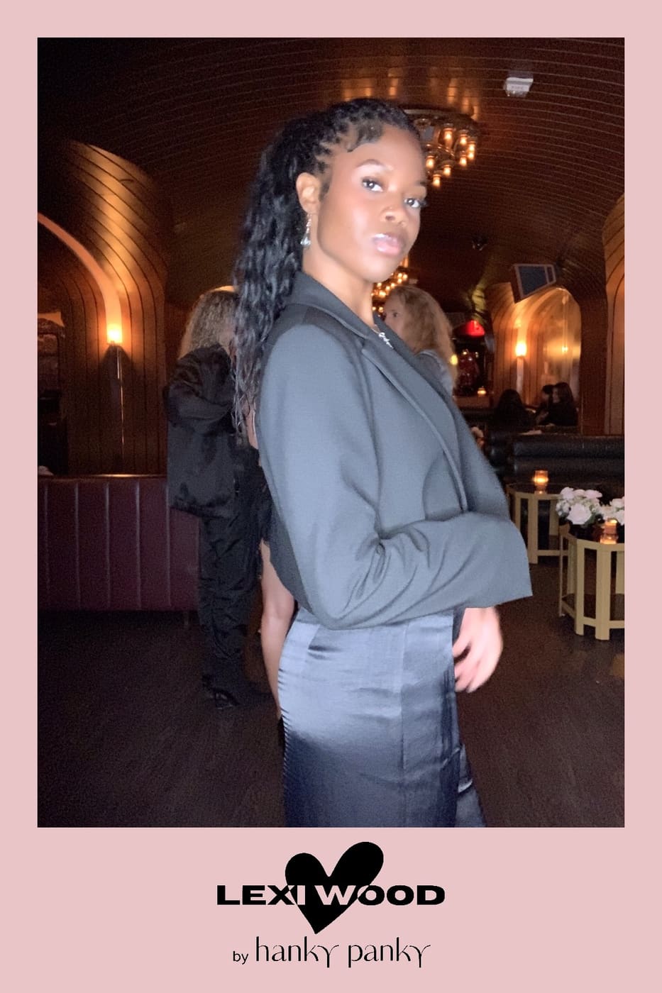 Guest in a cropped gray blazer and satin skirt at the brand party