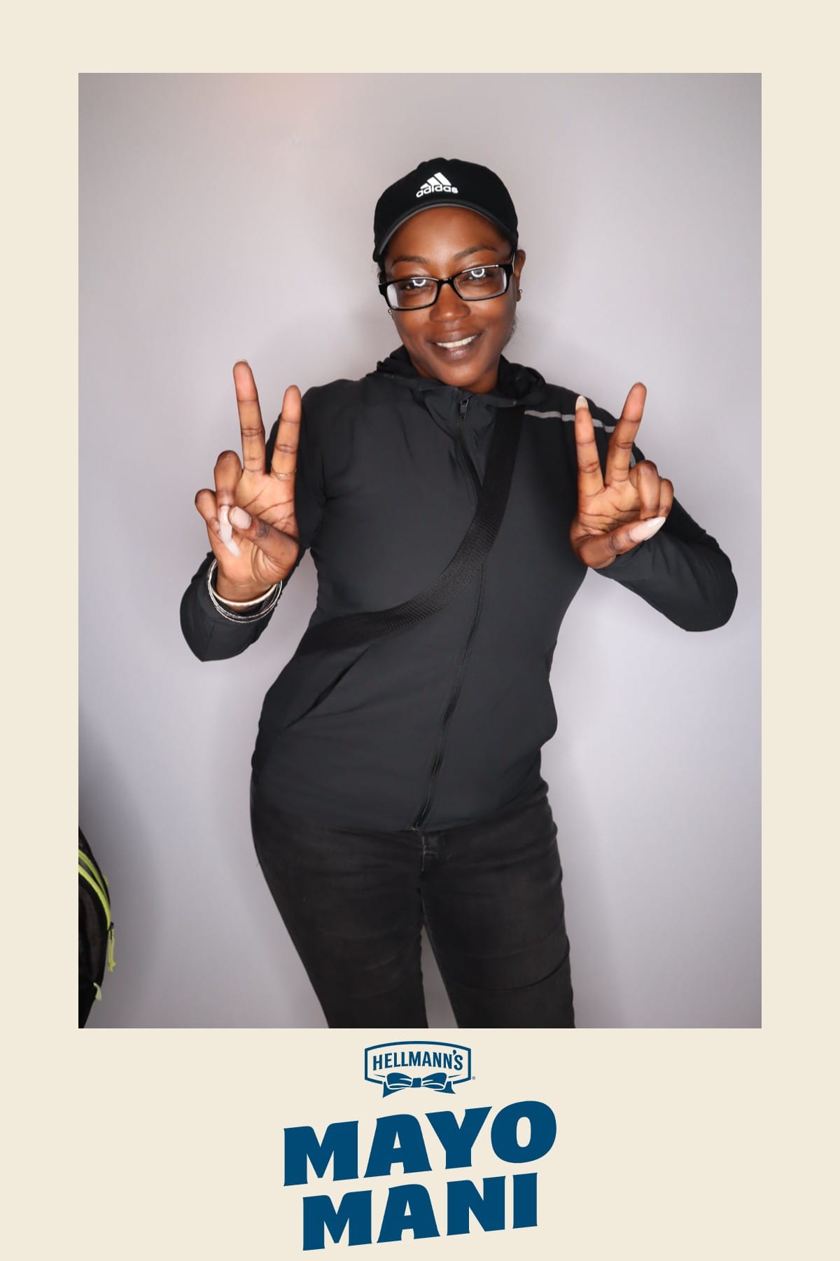 Guest in an Adidas cap throwing up peace signs at the Hellmann's Mayo Mani activation