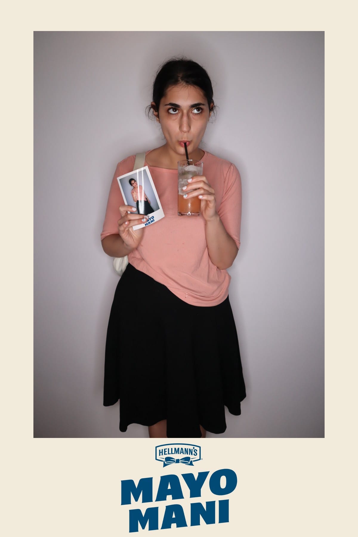 Guest sipping a cocktail and holding her Mayo Mani instant print