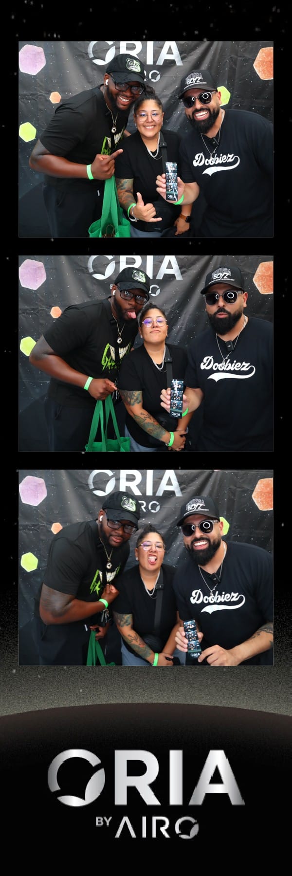 Three friends in black posing with drinks at the Oria by Airo booth