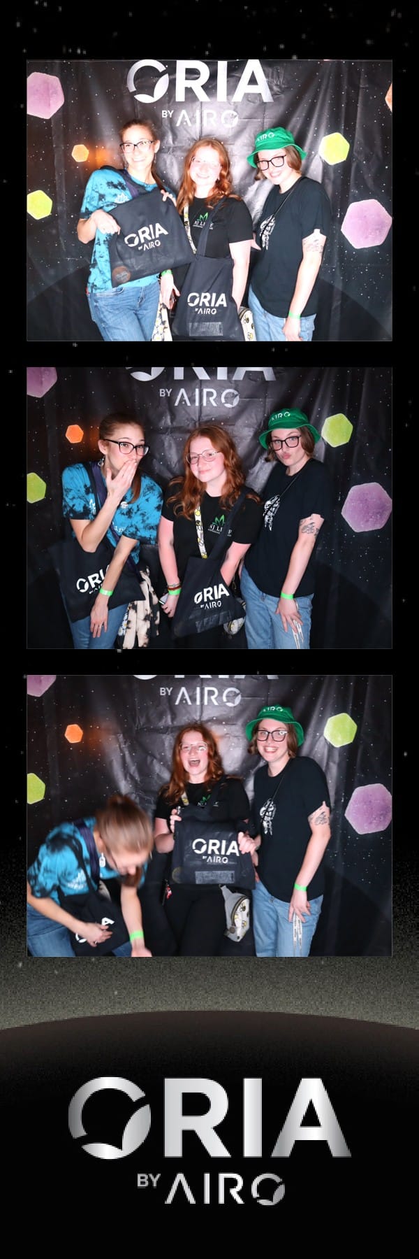 Three friends posing at the Oria by Airo booth, one holding printed strips