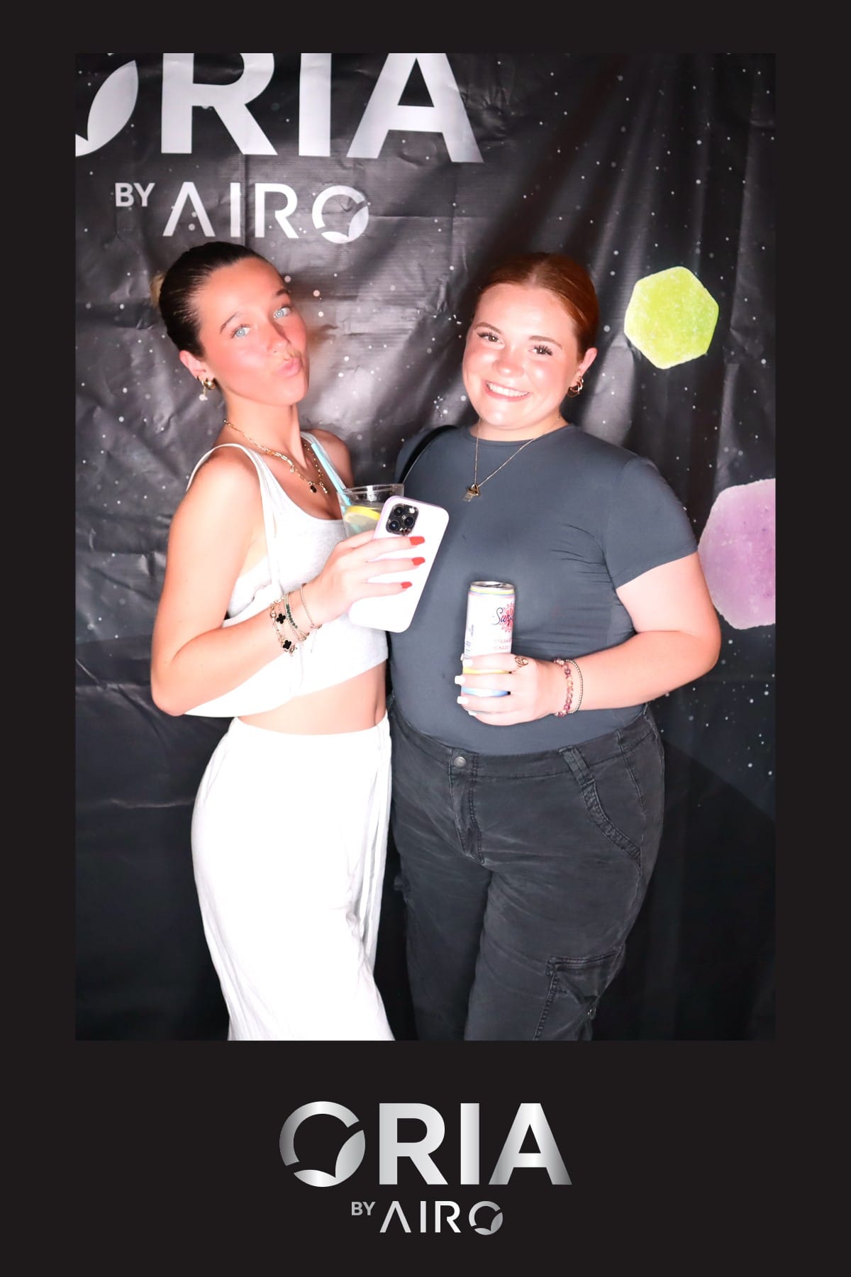 Three friends posing together at the Oria by Airo booth in party lighting