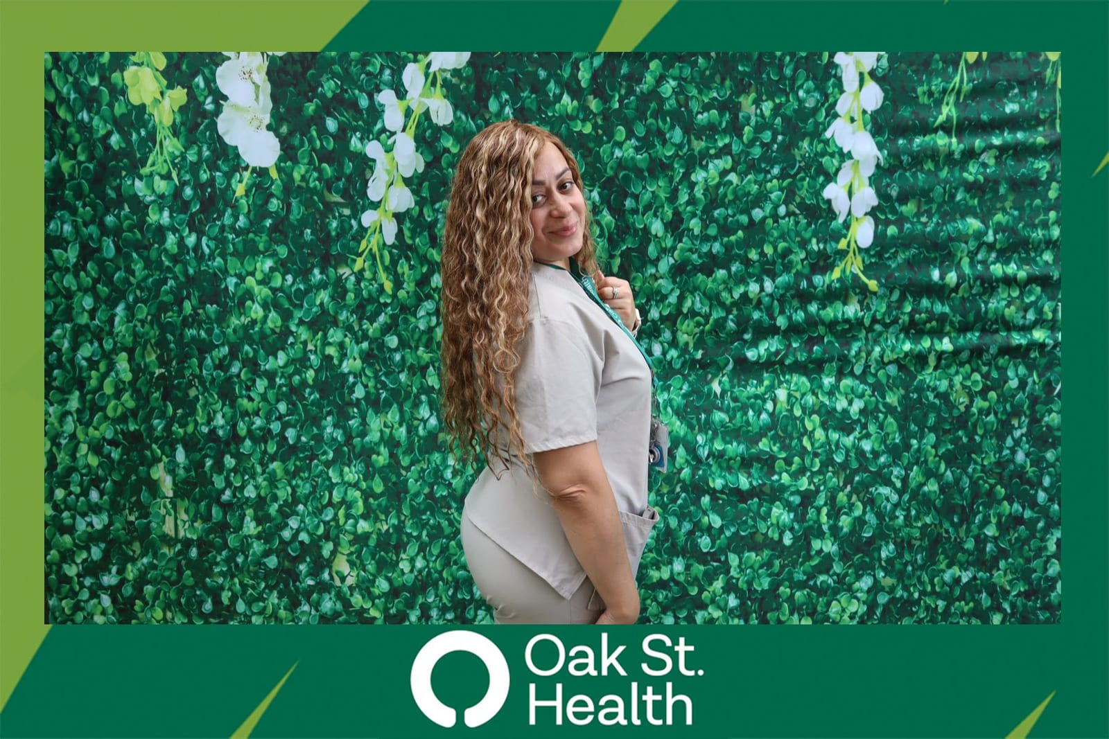 Guest posing solo at the Oak St. Health flower wall booth