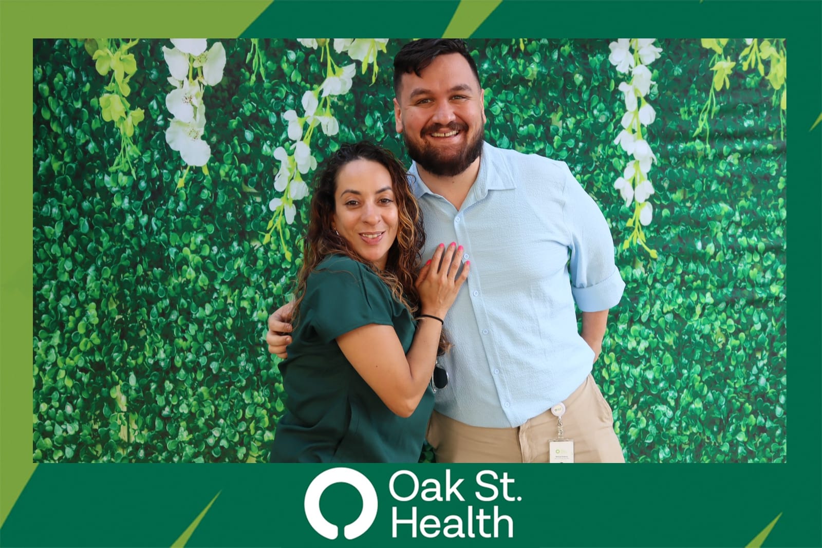 Couple posing together at the Oak St. Health flower wall celebration