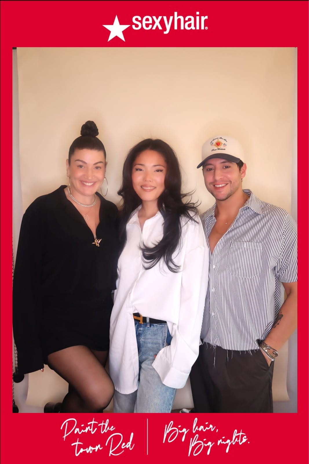 Three SexyHair team members posing together at the Paint the Town Red photo booth
