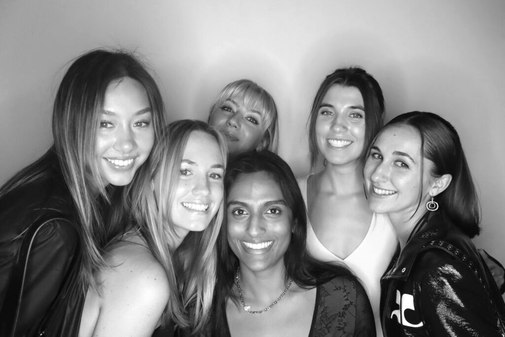 Friends crowding into a glam booth portrait at a Brooklyn celebration