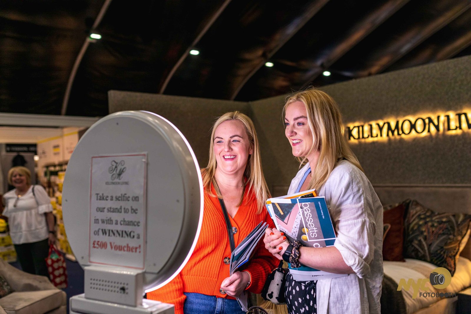 Guests taking a selfie at a branded booth kiosk on a trade show stand