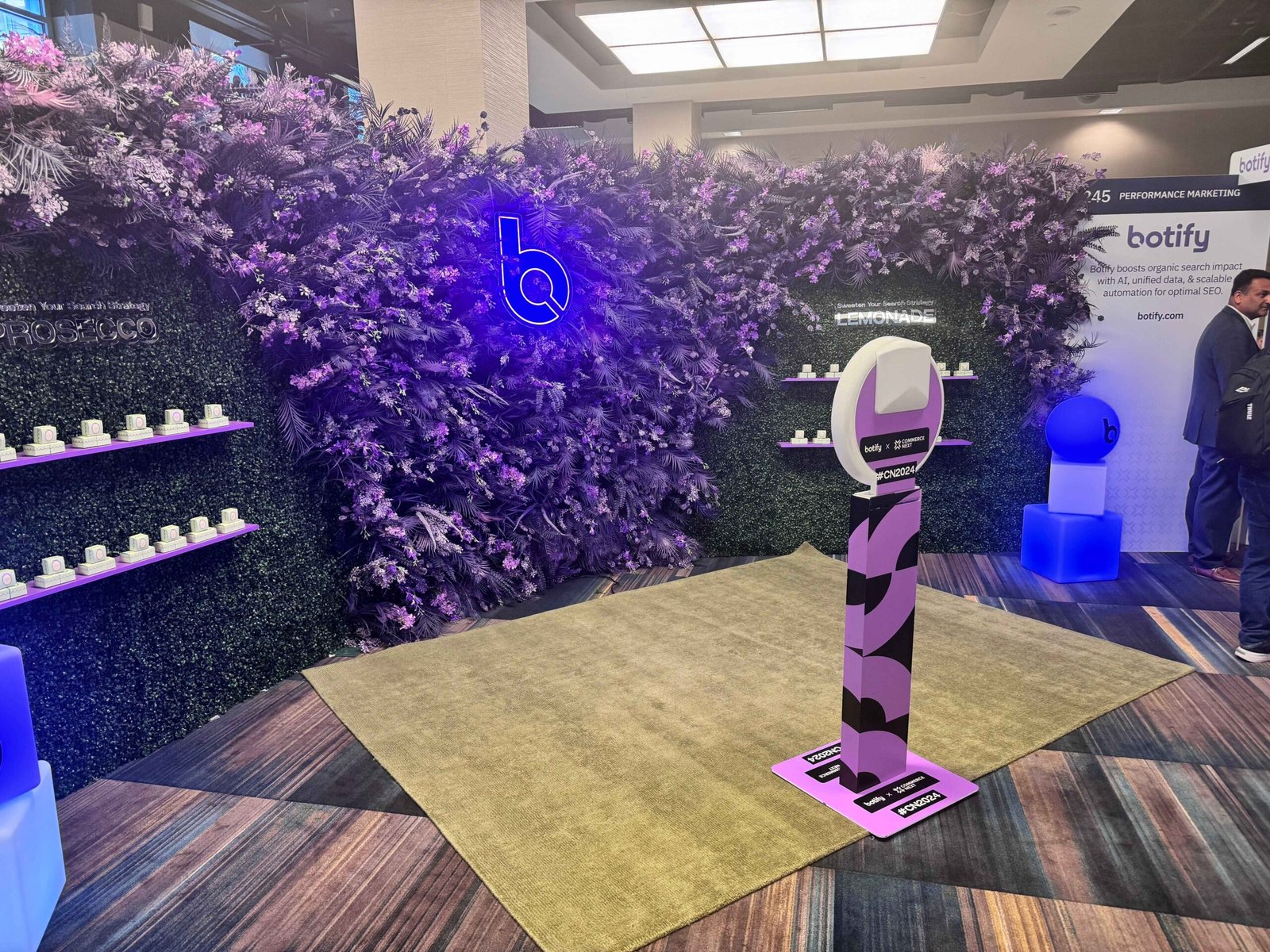 Branded selfie kiosk with purple flower wall at a conference activation