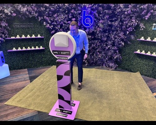 Attendee walking up to a branded selfie kiosk at a conference stand