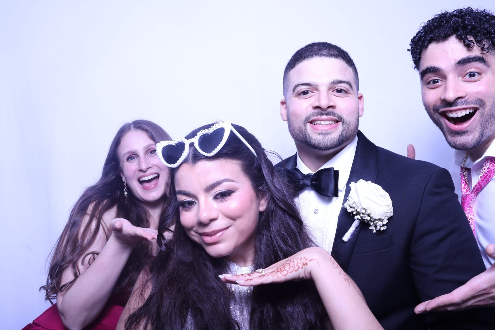 Bride and groom laughing with friends in the photo booth at a New York wedding